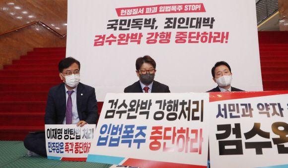 국민의힘 권성동 원내대표(가운데)가 27일 오전 서울 여의도 국회 로텐더홀 입구에서 검찰 수사권 기소권 분리 법안 강행처리 저지를 위한 연좌농성에 돌입하고 있다. 왼쪽부터 송언석 원내수석부대표, 권 원내대표, 성일종 정책위의장.2022. 4. 27  김명국 기자