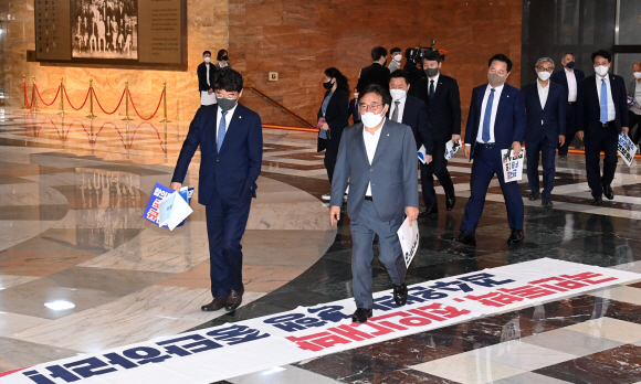 30일 서울 여의도 국회에서 열린 본회의에서 더불어민주당 의원들이 본회의장으로 입장하고 있다. 밑에 깔려 있는 현수막은 이 법안을 반대하는 내용의 국민의힘 현수막. 이날 국회는 검찰의 수사권과 기소권을 분리하는 내용의 검찰청법 개정안을 통과시켰다. 2022.04.30 오장환 기자