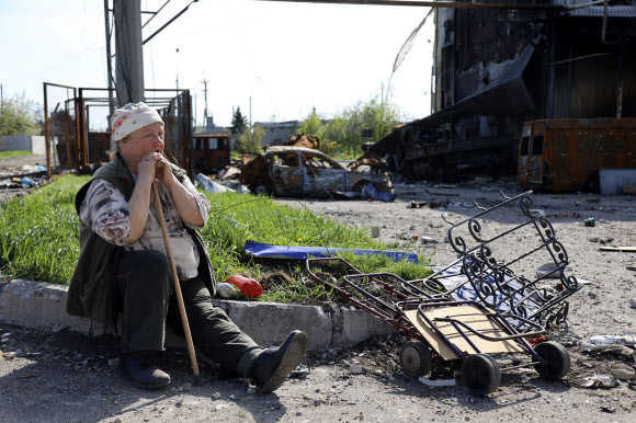 우크라이나 마리우폴에서 한 여성이 지친 모습으로 도로에 주저 앉아 있는 모습. 2022.05.01 AP 연합뉴스