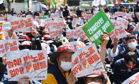 1일 오후 서울 중구 세종대로에서 민주노총 조합원들이 2022 세계 노동자 대회에 맞춰 차별 없는 노동권을 요구하는 손팻말을 들고 있다. 안주영 전문기자