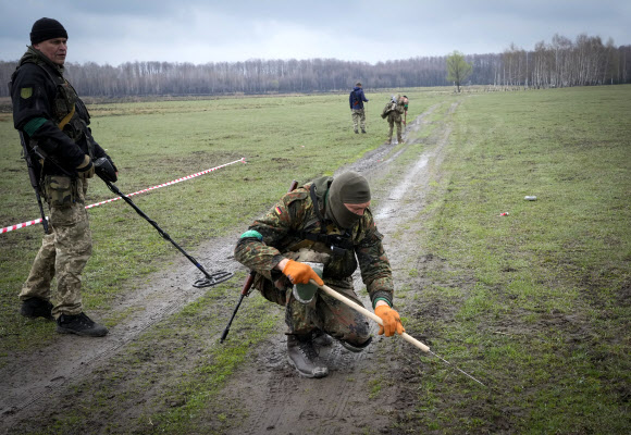 러시아군이 들판에 남긴 지뢰를 수색하고 있는 우크라이나군. 2022.05.03 AP 연합뉴스