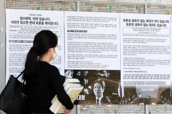 3일 한 대학생이 서울 서대문구 연세대에서 ‘검수완박’을  비판하는 대자보를 읽고 있다. 연합뉴스