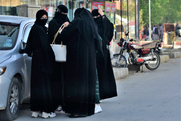 아프가니스탄 집권세력 탈레반이 모든 여성은 공공장소에서 부르카를 입어야 한다고 칙령을 발표한 7일(현지시간) 카불 여성들이 니캅 복장으로 거리에 서 있다. 부르카는 눈까지 가리는 반면, 니캅은 눈은 드러낼 수 있어 탈레반 포고령 위반에 해당한다. 카불 AFP 연합뉴스 