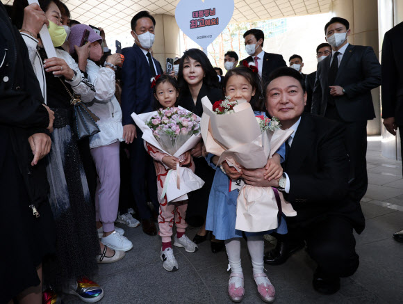윤석열 대통령과 김건희 여사가 10일 오전 제20대 대통령 취임식에 참석하기 위해 서울 서초구 서초동 자택을 나서며 주민들로부터 꽃다발을 받고 있다. 2022.5.10 연합뉴스