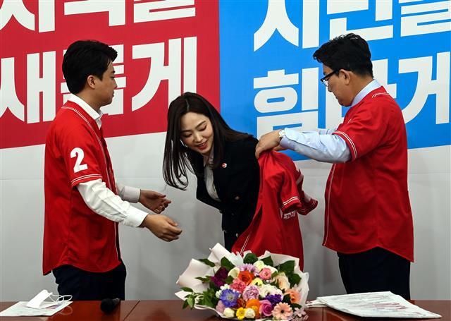 당구선수 차유람 선수(가운데)가 13일 서울 여의도 국회에서 열린 국민의힘 중앙선거대책위원회 회의에 앞서 이준석 대표(왼쪽)와 권성동 원내대표의 입당 환영을 받으며 유니폼을 입고 있다. 2022.5.13 국회사진기자단