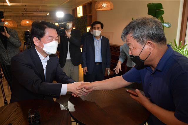 안철수 국민의힘 성남 분당갑 국회의원 후보가 13일 오전 경기도 성남시 분당구 대장동의 한 카페에서 열린 대장동 원주민 간담회에 참석해 대장동 피해주민과 인사하고 있다. 2022.5.13 뉴스1