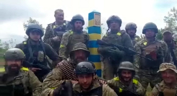 15일(현지시간) 우크라이나 제2도시인 동북부 하르키우 인근 접경 지대에서 러시아 국경 표지선을 배경으로 기념 촬영 중인 우크라이나군 제127여단 227대대 병사들. 우크라이나 국방부는 이날 자국군이 하르키우를 탈환하고 러시아군을 국경선까지 몰아냈다며 이 영상을 소셜미디어에 공개했다.  하르키우 로이터 연합뉴스
