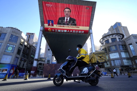 리커창 중국 국무원 총리가 지난 3월 베이징 인민대회당에서 열린 전국인민대표회의 개막식에 참석해 올해 정부 업무계획을 보고하는 내용이 베이징의 한 쇼핑몰 화면으로 생중계되고 있다. 베이징 AP 연합뉴스
