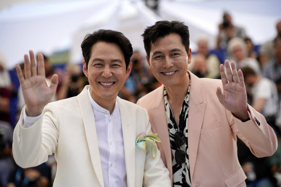 <yonhap photo-8898=“”> Lee Jung-j</yonhap>  Lee Jung-jae, left, and Jung Woo-sung pose for photographers at the photo call for the film ‘Hunt’ at the 75th international film festival, Cannes, southern France, Thursday, May 19, 2022. (AP Photo/Daniel Cole)/2022-05-19 19:52:31/ <연합뉴스
