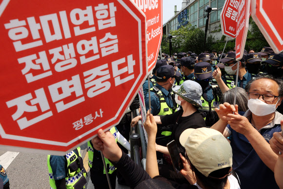 한미정상회담이 열리는 21일 오후 서울 용산구 미군기지 13번 게이트 건너편에서 평화와통일을여는사람들(평통사) 관계자들이 한미일 미사일방어체계(MD) 동맹·쿼드 가입 반대 등을 촉구하고 있다. 이날 조 바이든 미국 대통령은 미군기지 13번 게이트를 통해 용산 대통령 집무실을 방문했다. 2022.5.21 연합뉴스