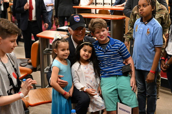 US President Joe Biden poses with a group of children while meeting with members of the US military and their families at the bowling alley at Osan Air Base in Pyeongtaek on May 22, 2022. AFP 연합뉴스
