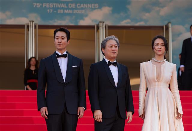 영화감독 박찬욱과 배우 박해일·탕웨이가 23일 오후(현지시간) 제75회 칸 국제영화제가 열리고 있는 프랑스 남부 칸 ‘팔레 데 페스티벌’(Palais des Festivals)에서 경쟁부문 진출작 영화 ’헤어질 결심‘ 월드 프리미어 시사회에 참석하기 위해 레드카펫을 지난 뒤 청중들에게 인사하고 있다. 2022.5.24 칸 뉴스1