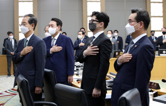 윤석열 대통령이 26일 정부세종청사에서 열린 첫 정식 국무회의에서 한덕수 국무총리, 한동훈 법무부 장관을 비롯한 국무위원들과 국기에 대한 경례를 하고 있다. 2022. 5. 26 박지환 기자