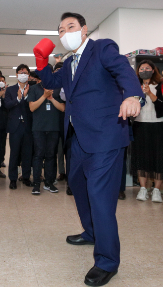 윤석열 대통령이 26일 정부세종청사에서 경제조정실 직원으로부터 권투 글로브를 선물 받은 뒤 ‘규제 타파’ 등을 외치며 어퍼컷 세리머니를 하고 있다. 2022. 5. 26 박지환 기자