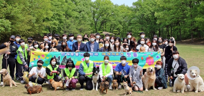 대구대 반려동물산업학과 학생들이 경산캠퍼스 비호동산에서 동물매개치료견인 반달이(보더콜리)와 초코(믹스견)의 입양 1주년을 기념한 돌잔치를 열고 있다. 대구대 제공