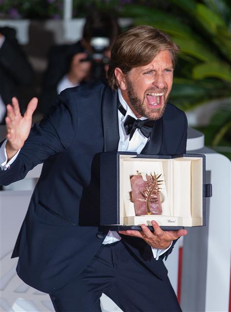 제75회 칸 국제영화제 폐막일인 28일(현지시간) 프랑스 남부 칸 ‘팔레 데 페스티벌’(Palais des Festivals)에서 ’트라이앵글 오브 새드니스’(TRIANGLE OF SADNESS)로 황금 종려상을 거머쥔 루벤 외스틀룬드 감독이 환호하고 있다.  이번 황금종려상 트로피는 75주년 기념으로 제작됐으며  다이아몬드 100개를 수놓아 장식했다. 2022.5.29 뉴스1