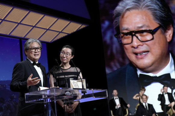 박찬욱(왼쪽) 감독이 28일(현지시간) 프랑스 칸 뤼미에르 대극장에서 열린 제75회 칸국제영화제 시상식에서 영화 ‘헤어질 결심’으로 감독상을 받은 후 소감을 밝히고 있다. 그는 한국 감독으로서는 ‘취화선’(2002)을 연출한 임권택 감독에 이어 두 번째 감독상 수상자가 됐다.  AP 연합뉴스