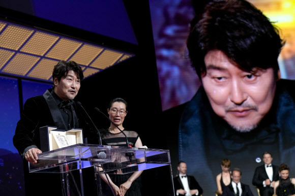 배우 송강호(왼쪽)가 28일(현지시간) 프랑스 칸 뤼미에르 대극장에서 열린 제75회 칸국제영화제 시상식에서 영화 ‘브로커’로 남우주연상을 받은 후 소감을 말하고 있다. 송강호는 이날 칸영화제에서 한국 배우 최초로 남우주연상을 수상했다.  AP 연합뉴스