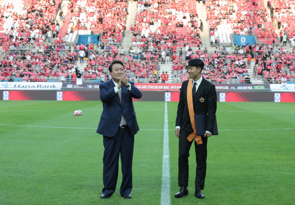 윤석열 대통령이 2일 서울월드컵경기장에서 2002 한일월드컵 20주년 기념 평가전 대한민국-브라질의 경기에 앞서 잉글랜드 프로축구 프리미어리그(EPL)에서 아시아 선수 최초로 득점왕을 차지한 손흥민에게 체육훈장 최고등급인 청룡장을 수여한 뒤 박수치고 있다. 2022.6.2 대통령실사진기자단