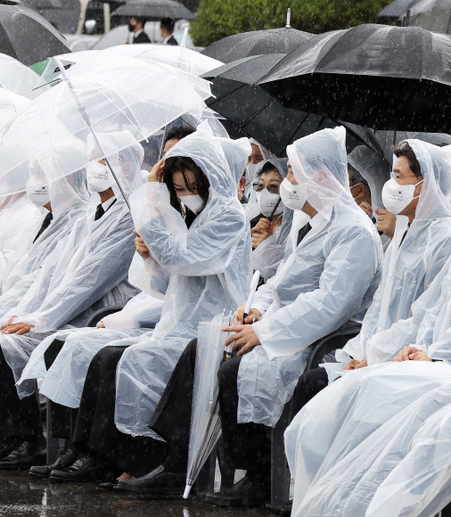 윤석열 대통령 부인 김건희 여사가 6일 서울 동작구 국립서울현충원에서 열린 제67회 현충일 추념식에서 우비의 모자를 쓰고 있다.2022.6.6   박지환 기자