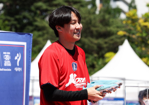 6일 오후 서울 마포구 서울월드컵경기장 북측 광장에서 2002년 월드컵 20주년 기념 대국민 프로젝트 ‘2022 KFA 풋볼 페스티벌’ 도중 열린 축구 스타 소장품 경매 행사에서 축구 국가대표팀 주장 손흥민이 지난 3월 24일 월드컵 예선 이란전에서 결승 골을 넣을 때 신었던 축구화를 1,600 만원에 낙찰받은 축구팬 이재호씨가 축구화를 들고 활짝 웃고 있다. 이날 경매에서 낙찰된 물건들의 대금은 모두 기부될 예정이다. 2022.6.6  연합뉴스