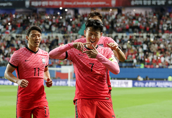 한국 축구대표팀의 손흥민(오른쪽)이 6일 대전월드컵경기장에서 열린 칠레와의 친선경기에서 후반 46분 프리킥 쐐기골을 넣은 뒤 ‘찰칵 세리머니’를 하고 있다. 이날 전반 12분 대표팀의 첫 골을 터뜨린 황희찬(왼쪽)도 함께 기뻐하고 있다. 대전 연합뉴스