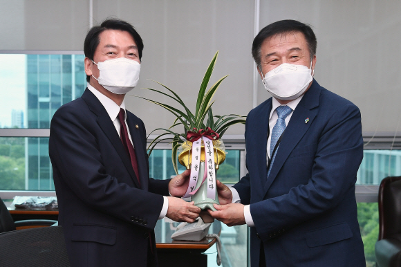 안철수 국민의힘 의원이 7일 서울 여의도 국회에서 이진복 대통령실 정무수석이 갖고 온 윤석열 대통령이 보낸 축하난을 전달받고 있다.2022. 6. 7  김명국 기자