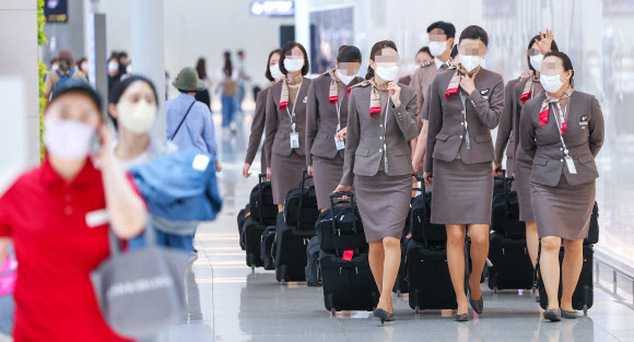 코로나19 확산으로 축소됐던 인천국제공항 국제선 운항이 정상화된 8일 오후 인천국제공항 제1여객터미널 출국장에서 승무원들이 비행을 위해 이동하고 있다. 이날 0시부터 도착편수 제한과 비행금지시간 등 국제선 증편 주요 규제들이 모두 해제됐다. 또한 이날부터 해외 입국자의 격리 의무도 해제됐다. 하지만 검사는 현행대로 입국 전·후 2회를 유지되며 입국 전에는 유전자증폭(PCR) 검사나 전문가용 신속항원검사를, 입국 후에는 3일 이내 PCR 검사를 받아야 한다. 2022.6.8  연합뉴스