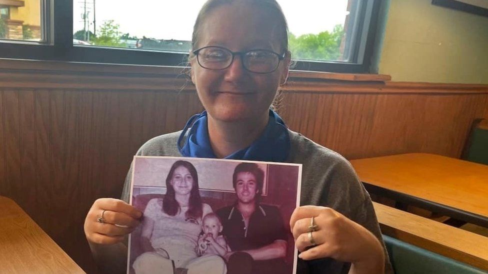 41년 만에 부모님과 자신의 정체성을 확인한 미국 여성 홀리 클루즈가 아기였을 때 부모님과 촬영한 사진을 들어 보이고 있다. 이 사진은 텍사스주 검찰이 건넨 것으로 보인다.  