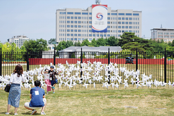 서울 용산공원 부지가 일반 국민에게 시범 개방되고 맞은 첫 주말인 12일 현장을 찾은 방문객이 대통령 집무실을 배경으로 기념 촬영을 하고 있다. 박윤슬 기자