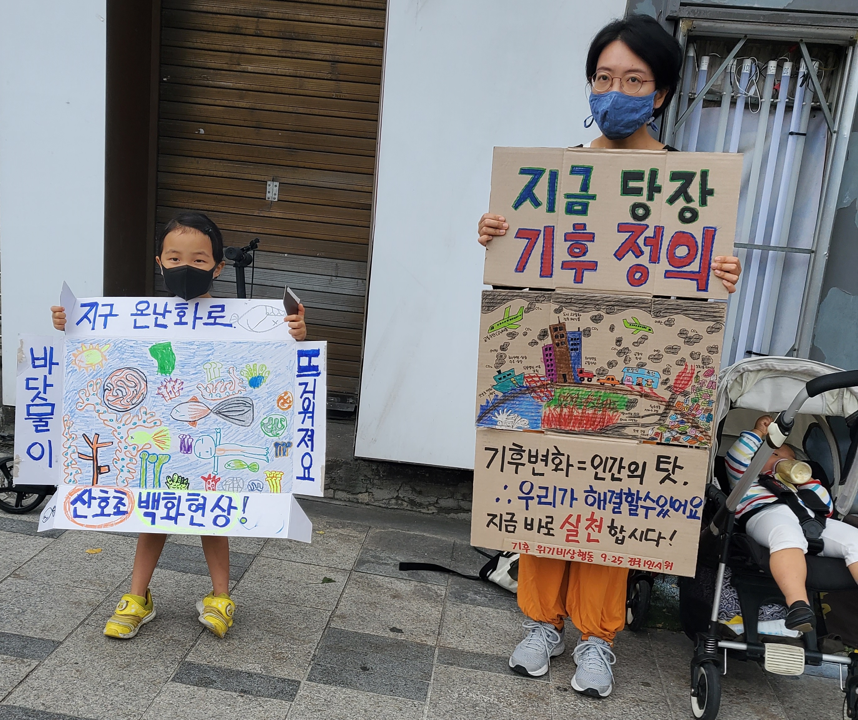 이서윤(오른쪽)씨가 지난해 9월 서울 종로구 경복궁역 근처에서 둘째 박서우(6)양과 직접 제작한 손 팻말을 들고 기후위기의 심각성을 알리는 모습. 이서윤씨 제공