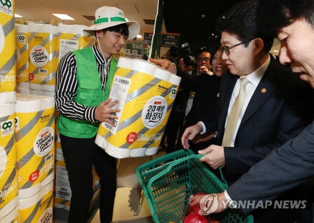 조명래 전 환경부 장관(오른쪽 두번째)이 2019년 4월 22일 서울 광진구 이마트 자양점에서 열린 ‘친환경소비 실천 캠페인’의 홍보를 위해 방문, 재생화장지를 고르고 있다.
