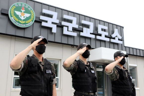 국방부가 23일 경기 이천시 국군교도소에서 신축 수용동 준공식을 앞두고 수용동의 내외부를 공개했다. 사진은 신축 관리동 앞에서 경례하는 교도병들. 2022.6.23  국방부 조사본부 제공