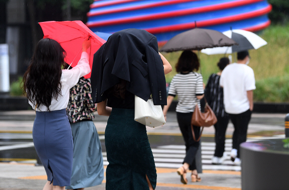 전국적으로 장맛비가 내리고 있는 23일 서울 세종대로 사거리 인근에서 한 시민이 우산을 챙겨오지 못해 겉옷으로 비를 피하며 이동하고 있다. 2022.6.23 오장환 기자