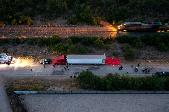 미국 텍사스주 사법당국 조사요원들이 27일(현지시간) 불법 이민을 희망하다 46명 이상이 주검으로 발견된 트럭 주변을 살펴보고 있다. 이 트럭은 샌안토니오 사우스웨스트 사이드의 철로 변에 주차된 채로 오후 6시쯤 발견됐다. 샌안토니오 AFP 연합뉴스