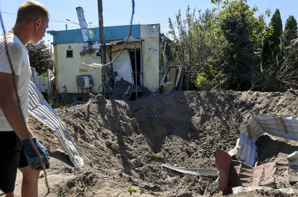 우크라이나 하르키우서 한 주민이 러시아에 의해 포격된 곳을 바라보고 있다. 2022.06.28 AP연합뉴스