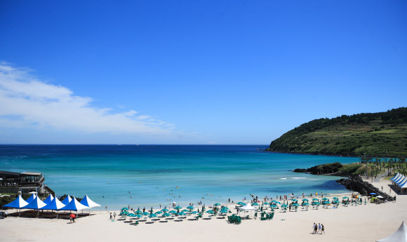 장마전선이 북상하며 무더운 날씨를 보이는 30일 오전 제주시 조천읍 함덕해수욕장을 찾은 관광객들이 물놀이를 하며 즐거운 시간을 보내고 있다. 이호와 협재, 함덕 등 제주 도내 12개 해수욕장은 7월1일 일제히 문을 열고 피서객을 맞이 한다. 2022.06.30. 뉴시스