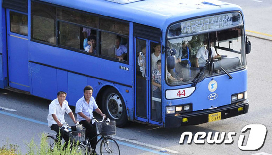지난 2013년 9월2일 북한 개성시 봉동리 개성공단 북측 근로자들이 버스와 자전거를 타고 퇴근하고 있다.  뉴스1