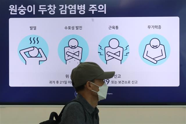 5일 인천국제공항 제1여객터미널 출국장 전광판에 표시된 원숭이두창 감염병 주의 안내문 앞을 한 시민이 지나가고 있다.   뉴스1