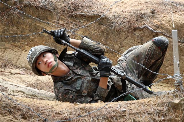 6일 오전 대구 육군 50사단 신병교육대대 각개전투 교장에서 각개전투 훈련에 투입된 훈련병들이 철조망을 통과하고 있다.  이들은 코로나19 사태로 이후 2년 5개월 만인 지난달 7일 재개된 가족동반 입영 행사를 통해 입대한 강철 160기 훈련병들이다. 2022.7.6 뉴스1
