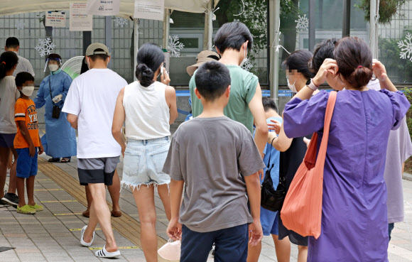 서울 서초구보건소 선별진료소에서 시민들이 코로나19 검사를 받기 위해 줄을 서 있다. 오미크론 변이인 BA.5가 확산하는 데다 기존의 백신 효력이 떨어지면서 확진자 증가세를 보이는 것으로 분석된다. 연합뉴스