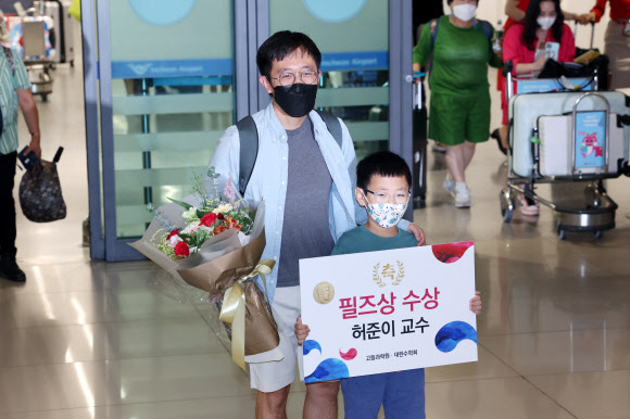 수학계 최고의 영예 중 하나인 필즈상을 받은 허준이 프린스턴대 교수 겸 고등과학원(KIAS) 석학교수가 8일 오전 인천국제공항 제1터미널을 통해 입국해 아들과 함께 기념촬영을 하고 있다. 2022.7.8  연합뉴스