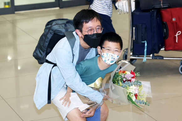 수학계 최고의 영예 중 하나인 필즈상을 받은 허준이 프린스턴대 교수 겸 고등과학원(KIAS) 석학교수가 8일 오전 인천국제공항 제1터미널을 통해 입국해 아들과 함께 기쁨을 나누고 있다. 2022.7.8  연합뉴스