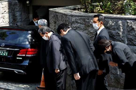 Japanese lawmaker Sanae Takaichi prays to the vehicle believed to be carrying the body of former Japanese Prime Minister Shinzo Abe, who was shot while campaigning for a parliamentary election, at his residence in Tokyo, Japan July 9, 2022. REUTERS 연합뉴스