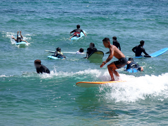 강한 햇볕이 쬐는 9일 오후 서귀포시 중문색달해수욕장에서 서핑객이 파도를 타고 있다. 2022.07.09. 뉴시스