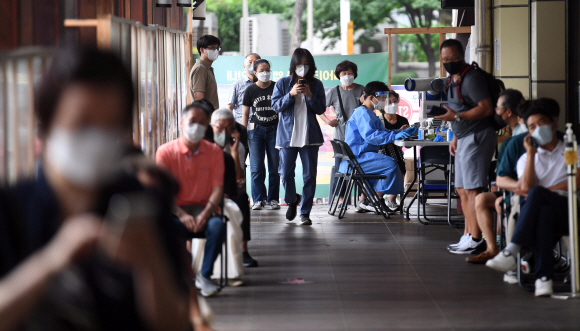예상보다 일찍 코로나19가 재유행 단계로 들어선 가운데 12일 서울 송파구 보건소 선별진료소에서 시민들이 코로나19 검사를 받기 위해 기다리고 있다. 박윤슬 기자
