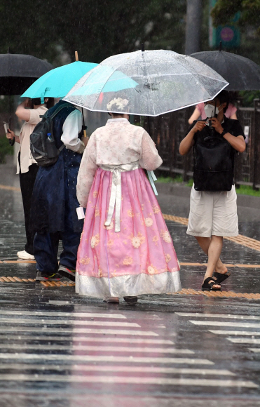 비가 내린 13일 서울 광화문사거리 인근에서 시민들이 우산을 쓰고 걸어가고 있다. 2022. 7. 13 박윤슬 기자