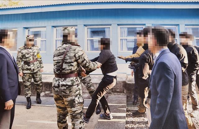 통일부는 지난 2019년 11월 판문점에서 탈북어민 2명을 북한으로 송환하던 당시 촬영한 사진을 12일 공개했다.  사진은 탈북 어민이 몸부림치며 북송에 저항하는 모습. 통일부 제공