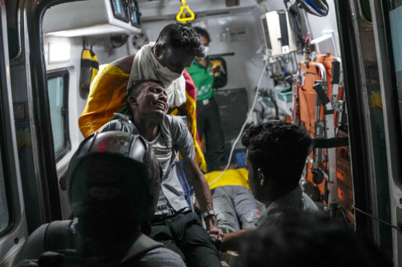 스리랑카 수도 콜롬보에서 13일 반정부 시위에 나섰다가 다친 남성이 앰뷸런스에 실리면서 고통스러워하고 있다. 콜롬보 AP 연합뉴스