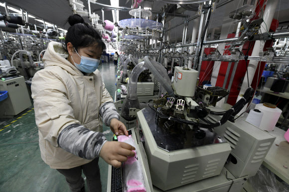 중국 중부 안후이성 푸난현의 한 양말 공장에서 여성 노동자가 작업을 하고 있다. 이날 발표된 중국의 2분기 성장률은 0.4%로 후베이성 우한 코로나19 집단감염 사태로 마이너스 성장을 기록한 2020년 1분기 이후 최저치를 기록했다. AP 연합뉴스